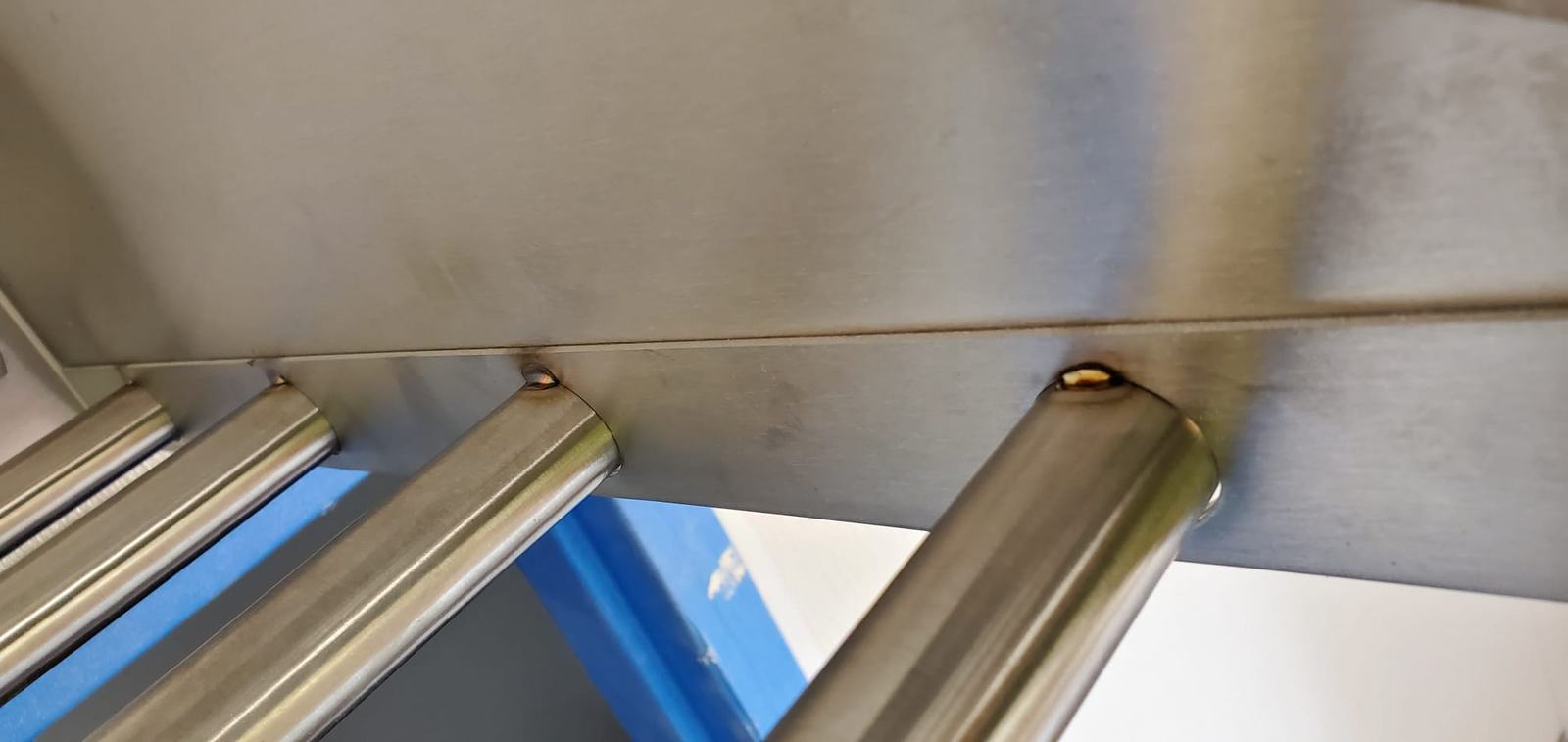 Stainless steel tube frame joints under a prep table, welded and polished